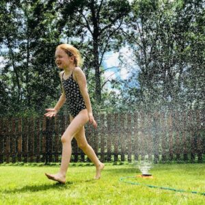 kid enjoying sprinkler in summer therapy for kids